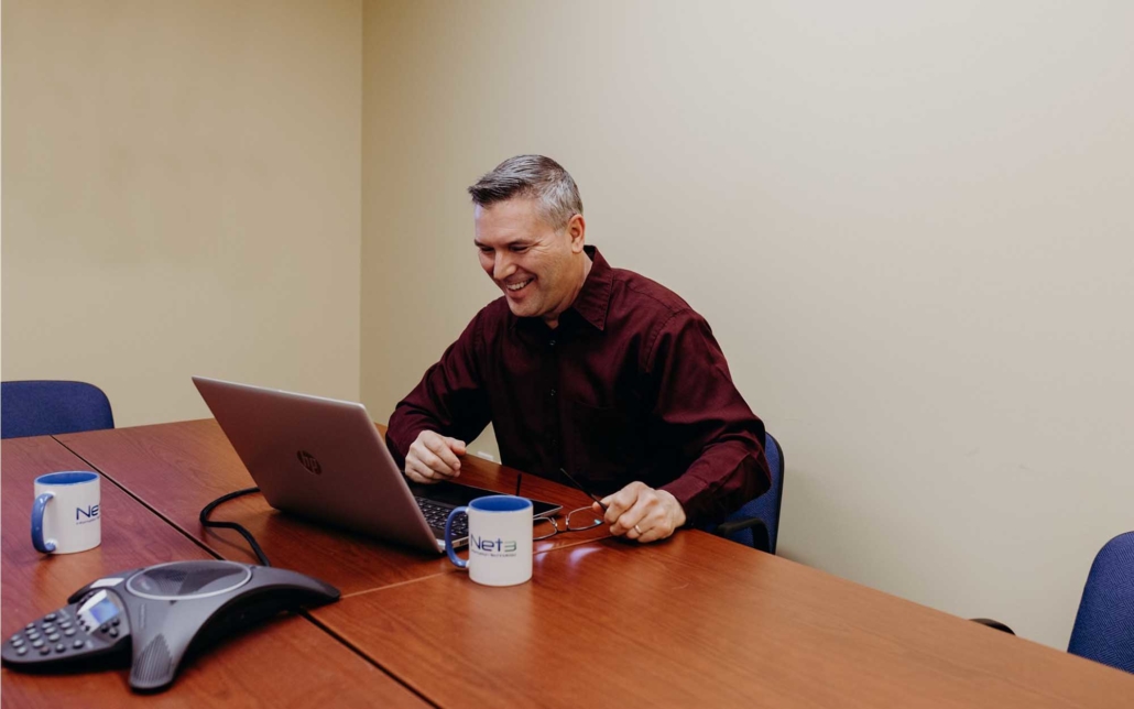 man smiling while looking at computer